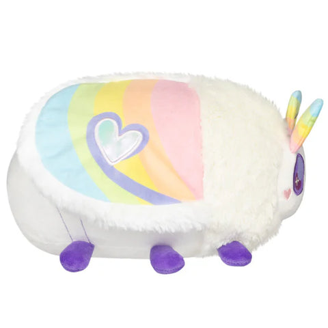 Image shows a side view of the stuffed moth. Its wings are pastel rainbow with a silver heart.