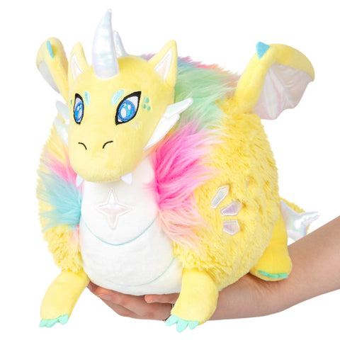 Image shows a yellow stuffed dragon with pastel rainbow fur around its neck