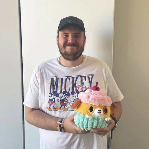 Image shows a man holding the stuffed pupcake.