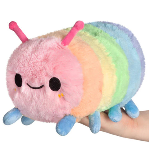 Image shows a stuffed pastel-colored rainbow caterpillar held in someone's palm