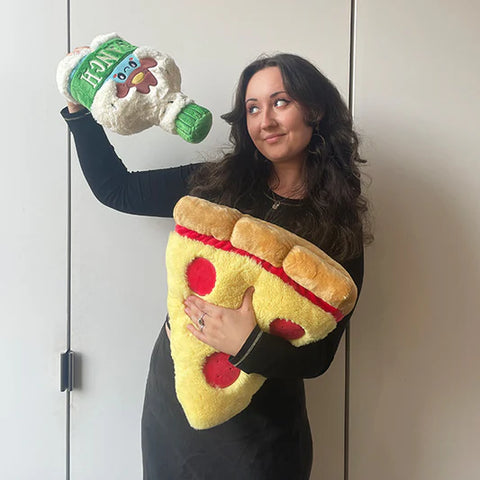 Image shows a woman holding the stuffed ranch bottle over a slice of stuffed pizza. It is slightly larger than her head.