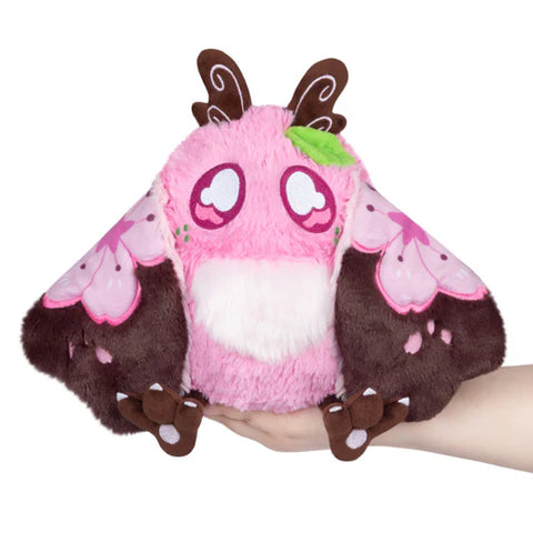 Image shows a brown and pink Sakura-themed baby Mothman.