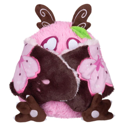 Image shows the sakura-themed baby mothman with his wings closed