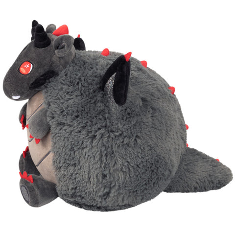 A side view of the plush grey dragon. It has red spikes on its wings and down its back.