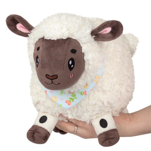 Image shows a chubby stuffed lamb with a floral bandana around its neck