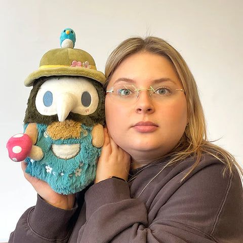 Image shows a woman holding the spring mushroom themed plague doctor. It is slightly larger than her head.