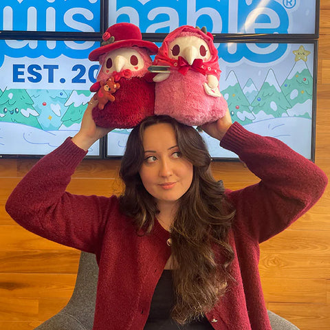 Image shows a woman holding the plague doctor & nurse above her head. One stuffy is about the size of her head.