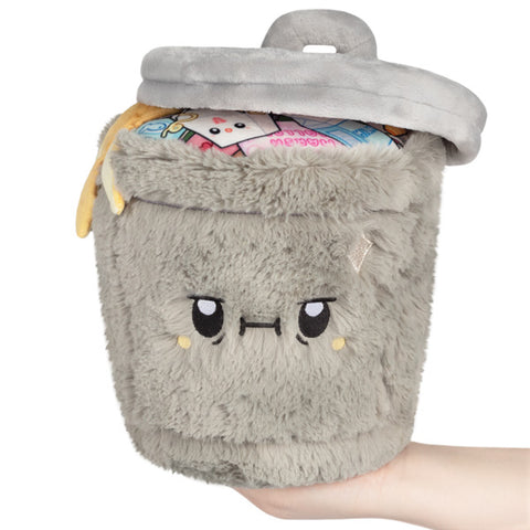 Image shows a stuffed trash can with the lid slightly off. It has a grumpy face.