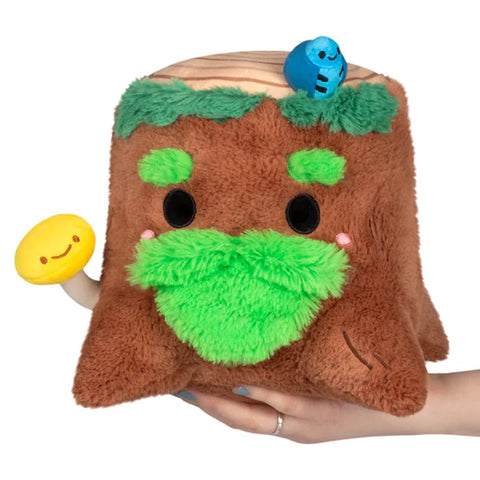 Image shows a stuffed tree stump with a moss beard and eyebrows. It has a bird on top and a mushroom sticking out.