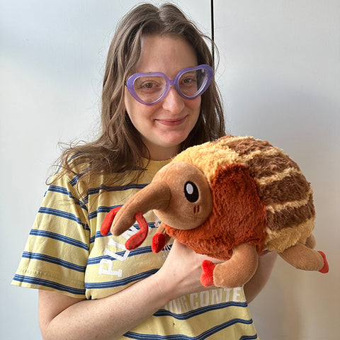 Image shows a woman holding the stuffed weevil. It is slightly larger than her head.