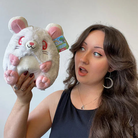 A woman holding the stuffed white rat. Its approximately the size of her head.