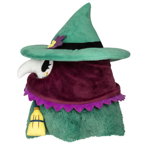 Image shows a side view of the stuffed witchy plague nurse. She wears a maroon bonnet and a teal witch hat.