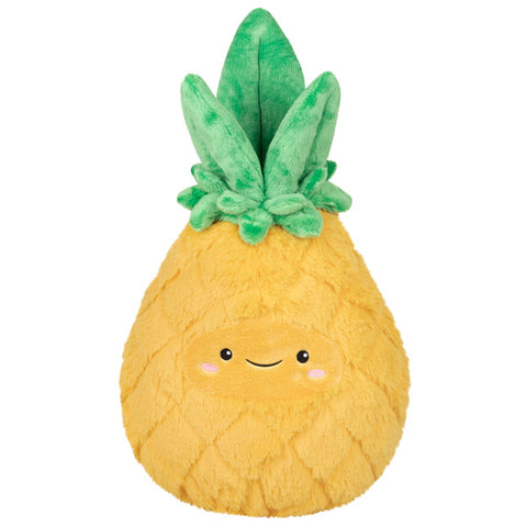 A plush pineapple toy with a yellow body, green leaves on top, and a smiling face.