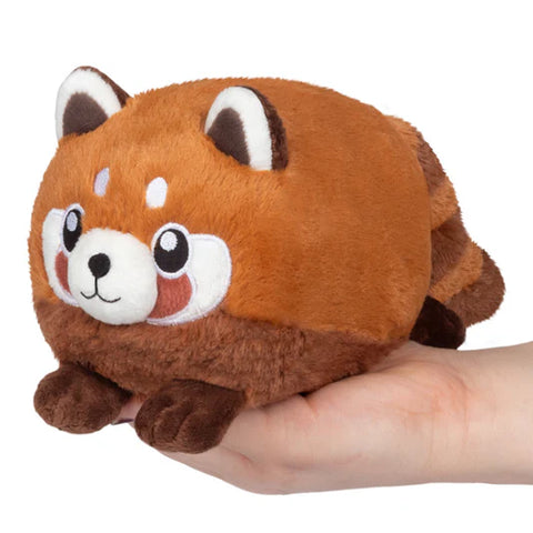 Image shows a round, stuffed red panda held in an adult's palm