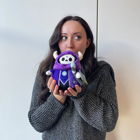 A woman holds the stuffed Lich. It is slightly smaller than her head.