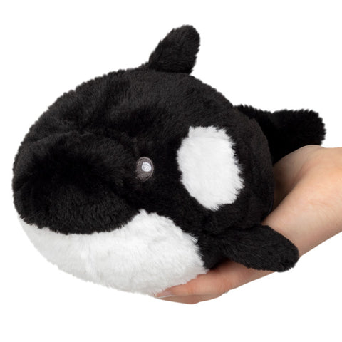 Image shows a stuffed orca whale held in someone's palm