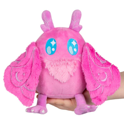 Image shows a pink stuffed baby mothman, held in someone's palm