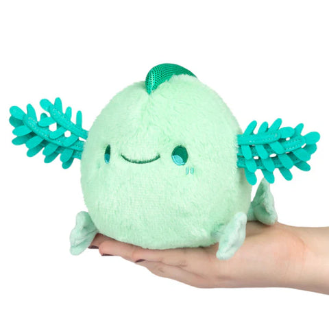 Image shows a stuffed mint-colored axolotl held in an adult's palm
