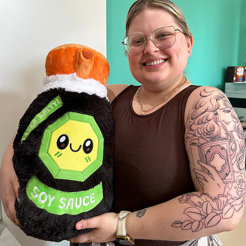 Image shows a woman holding the stuffed soy sauce. It is about as big as her torso.