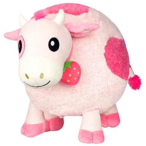 Image shows a round pink cow with a strawberry bell around its neck.
