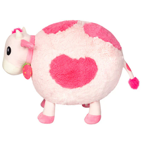 Image shows a side view of the stuffed pink cow. It is very round and has short legs.
