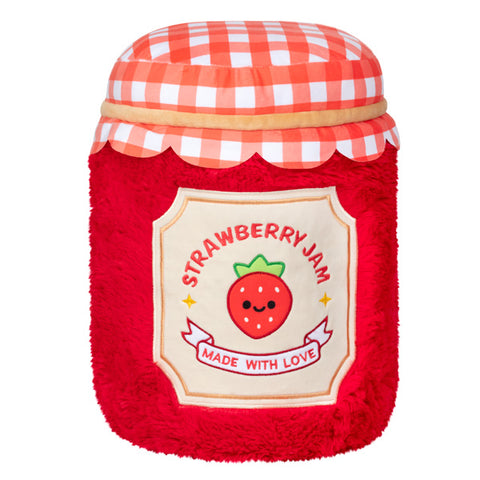 A back view of the plush strawberry jam. It has a label with a strawberry and words saying "Strawberry jam" and "made with love"