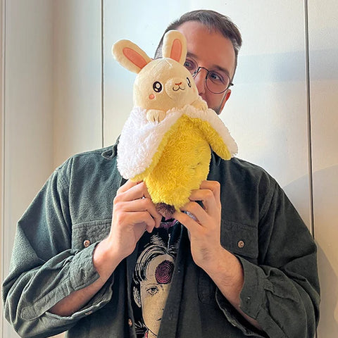 Image shows a man holding up the bunana. It is slightly taller than his face.