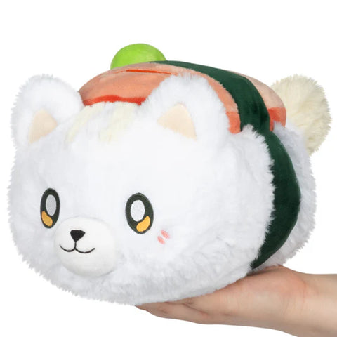 Image shows stuffed musubi sushi on top of a white cat