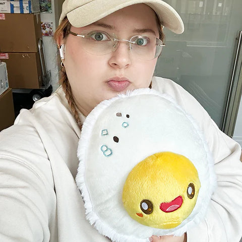 Image shows a woman holding the stuffed hard boiled egg. It is approximately the size of her head.