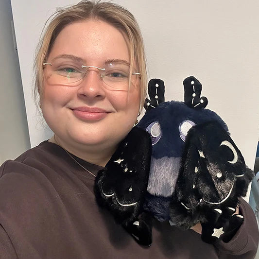 Image shows a woman holding the midnight mothman. It is approximately the size of her head.