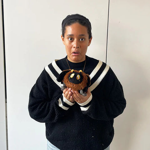 An African American woman holds the stuffed Death's Head Hawkmoth