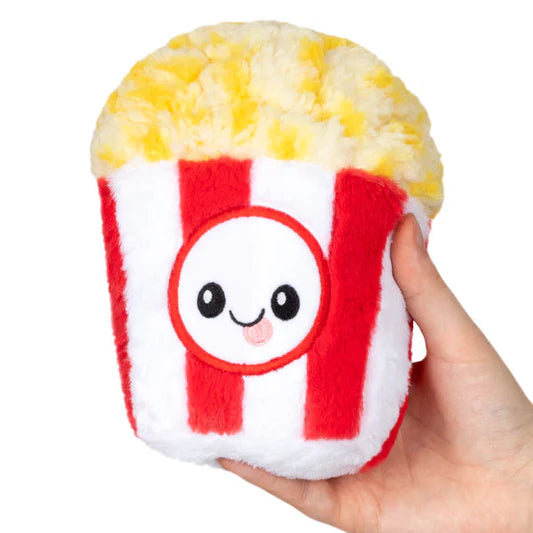 A stuffed tub of popcorn with a smiley face and tongue sticking out