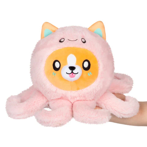 Image shows a stuffed Corgi wearing a pink octopus costume. The stuffy sits in someone's palm.