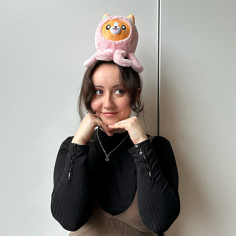 Image shows a woman with the stuffy on her head. It is approximately half the size of her head.