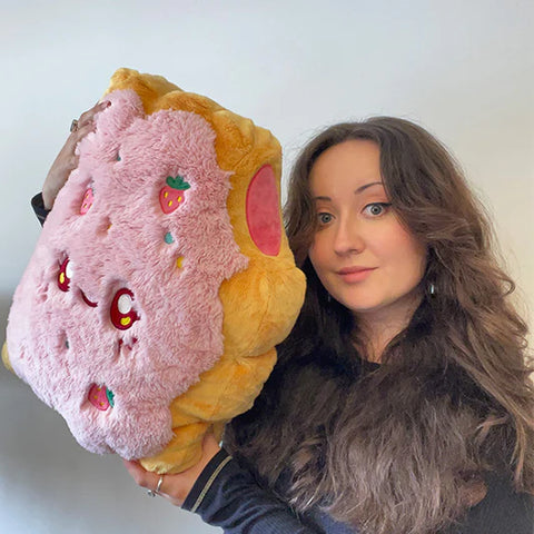 A woman holding the plush toaster tart. It is about the size of her torso.