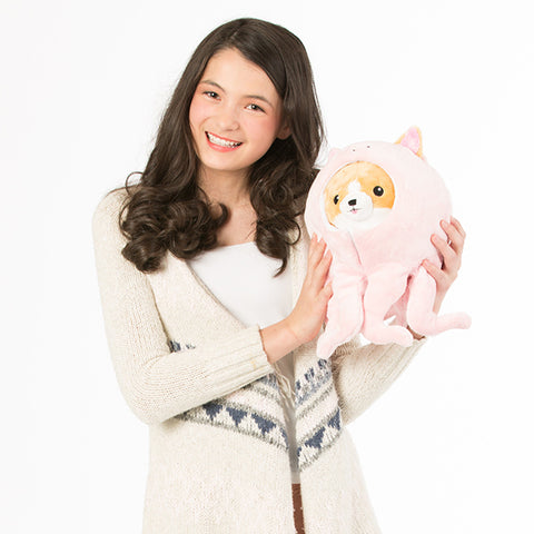 Image shows a woman holding the octopus corgi. It is slightly larger than her head.