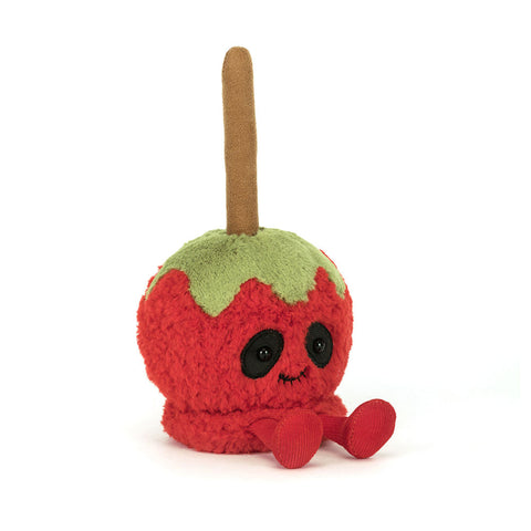 A red apple with a face and feet, dipped in green toffee, attached to a popsicle stick.