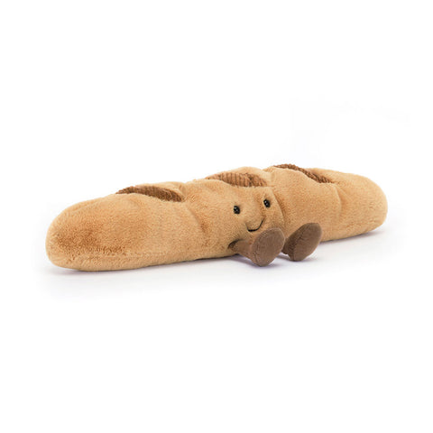 Plush toy shaped like a baguette with a face and feet on a white background