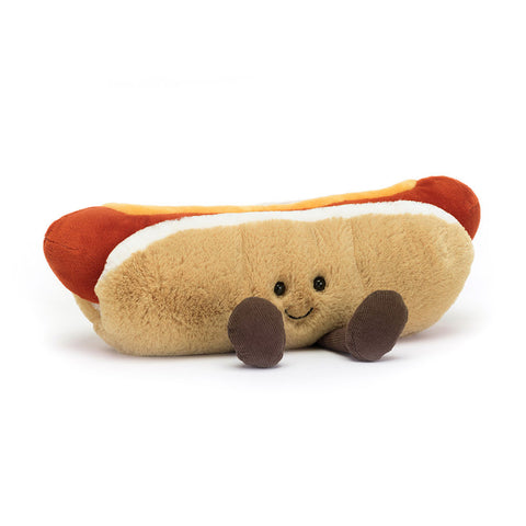 Image shows a stuffed hot dog in a bun. It has mustard on top and a happy face and feet.