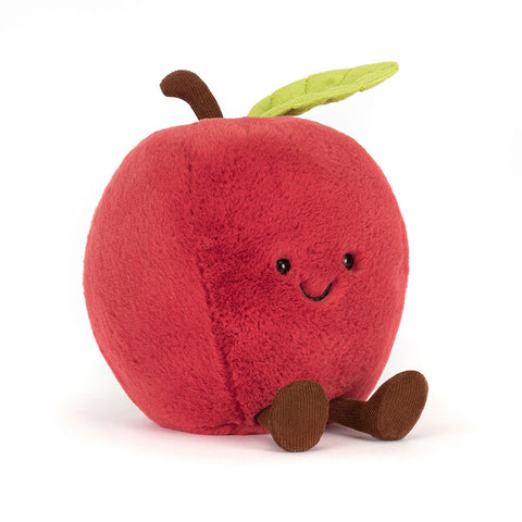 Image shows a stuffed red apple. It has one leaf on the stem, a happy face, and feet.