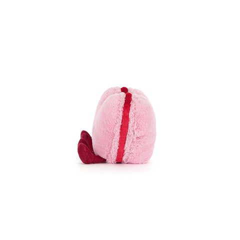 Side view of the plush pink macaron cookie. You can see the red filling and feet.