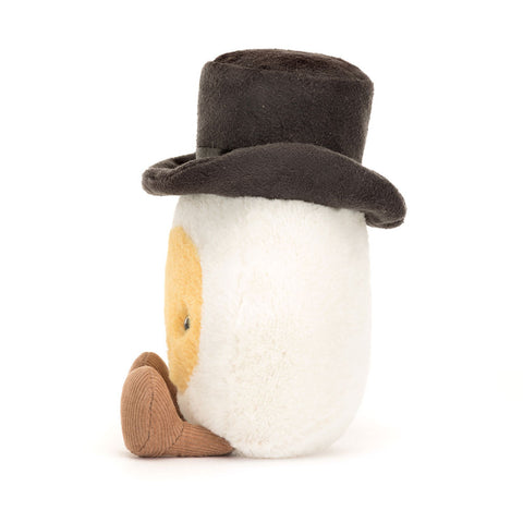 A side view of the stuffed egg wearing a top hat on a white background