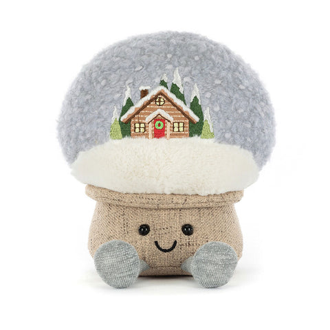 Plush toy with a snow globe design featuring a house and trees on a white background