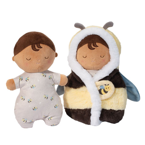 A plush doll wrapped in a bee blanket. The doll is also shown separately, with dark skin and dark brown hair.