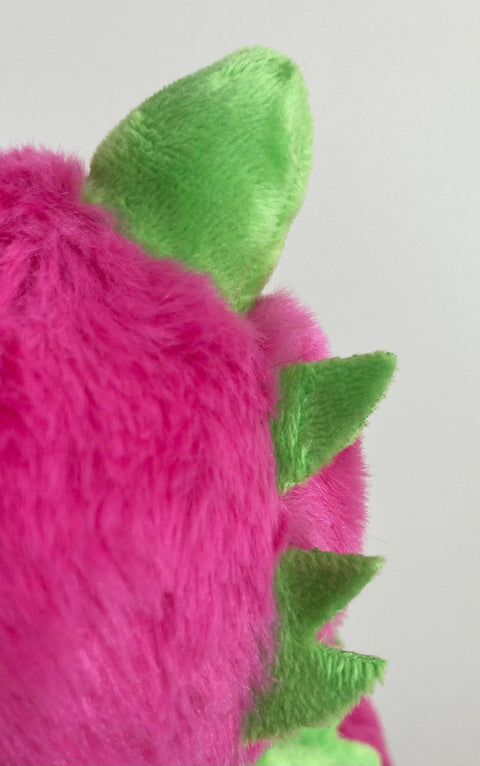 Close up of the dragonfruit dragon's spikes. They are green against bright pink fur.