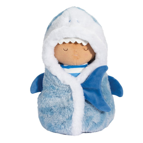 A plush doll wrapped in a blue, shark-themed blanket.