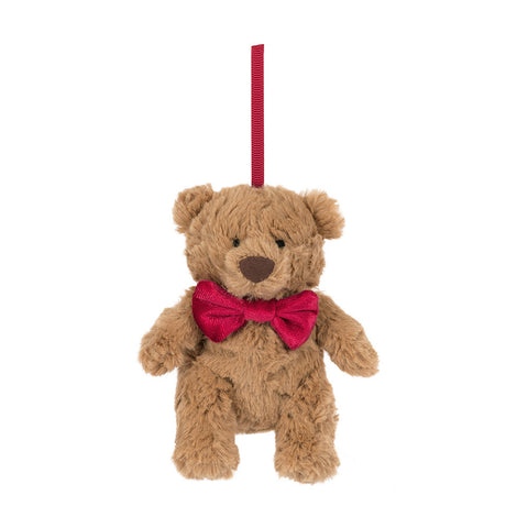 Plush teddy bear with a red bow tie on a white background. It hangs from a red ribbon.