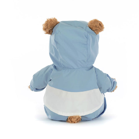 Back view of a stuffed teddy bear wearing a blue snow suit