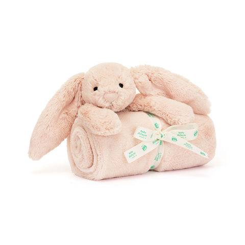 Soft pink colored bunny on top of a rolled up blanket