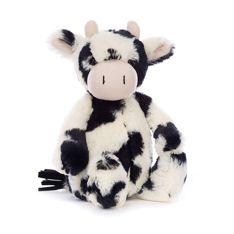Plush cow stuffed animal with black and white fur on a white background